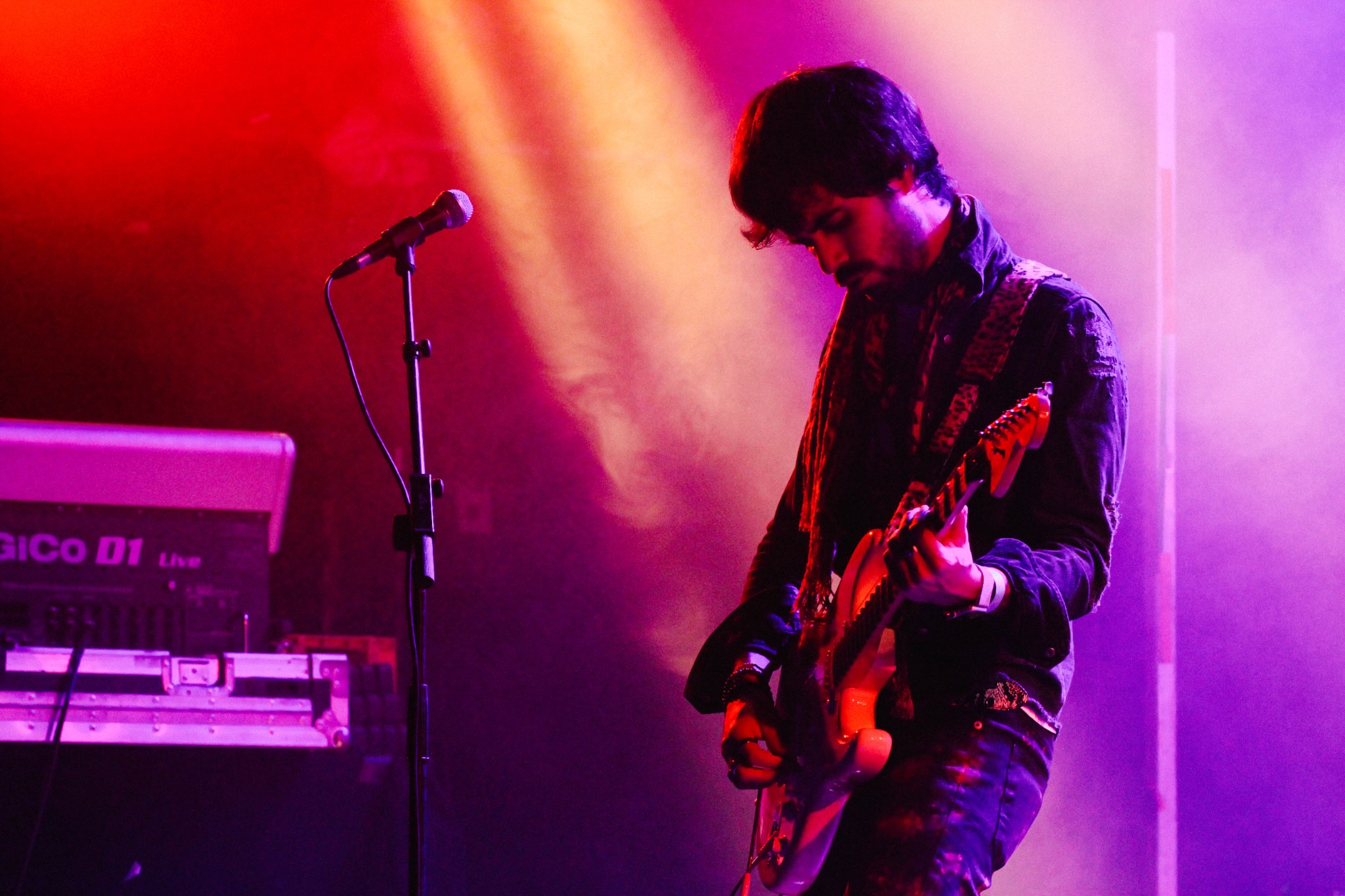 BONAHORA guitarist performing under red and purple stage lights